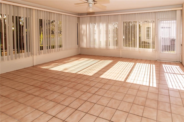 tiled spare room featuring ceiling fan