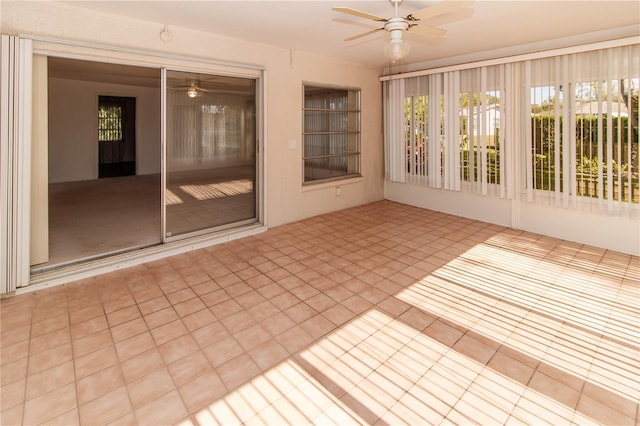 unfurnished sunroom featuring ceiling fan