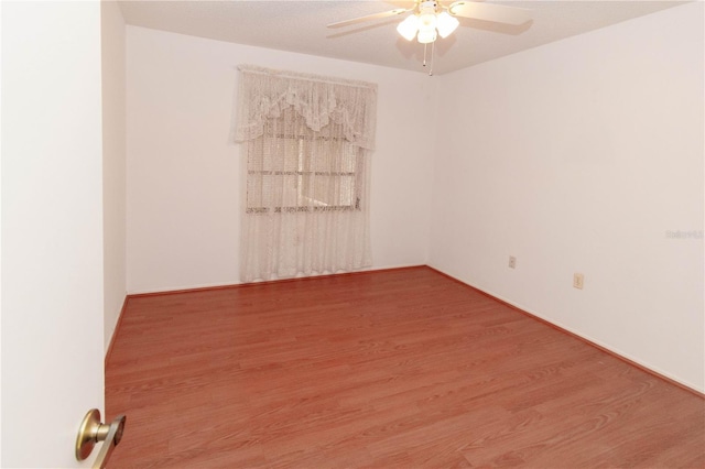 empty room with ceiling fan and wood finished floors