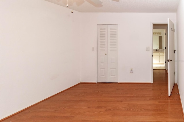 interior space featuring light wood-style flooring, baseboards, ceiling fan, and a closet