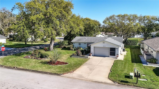 ranch-style house featuring a garage, concrete driveway, and a front lawn