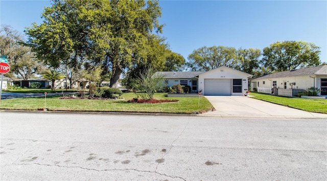 single story home with a garage, a front yard, and driveway