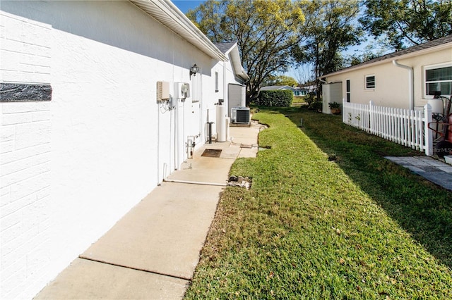 view of yard featuring fence and central air condition unit