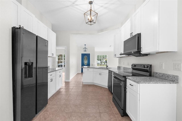 kitchen featuring a peninsula, black appliances, white cabinetry, and a sink