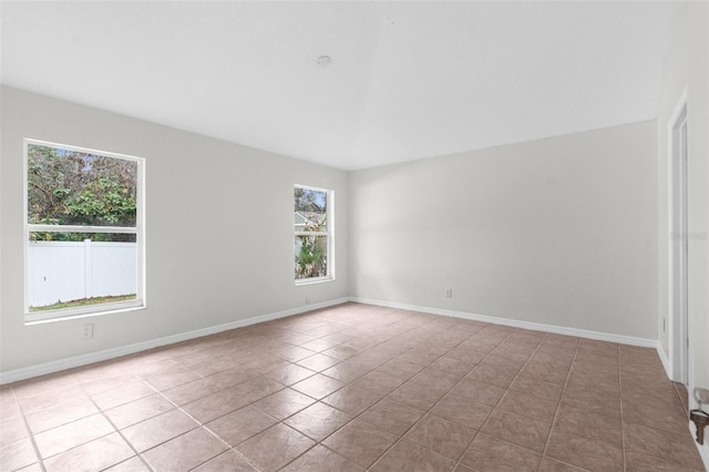 tiled empty room featuring baseboards