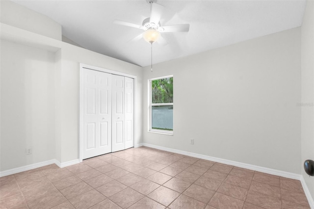 unfurnished bedroom with ceiling fan, a closet, tile patterned flooring, and baseboards
