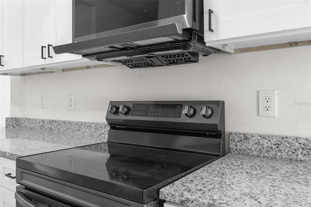 kitchen with appliances with stainless steel finishes, white cabinets, and light stone countertops