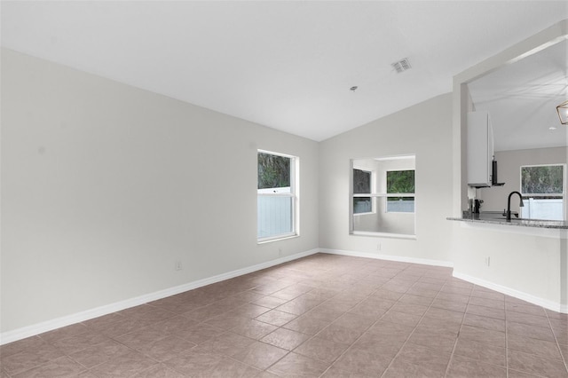 unfurnished living room featuring lofted ceiling, baseboards, visible vents, and a sink