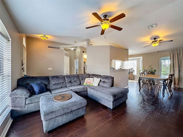 living room featuring visible vents, ceiling fan, vaulted ceiling, a textured ceiling, and wood finished floors