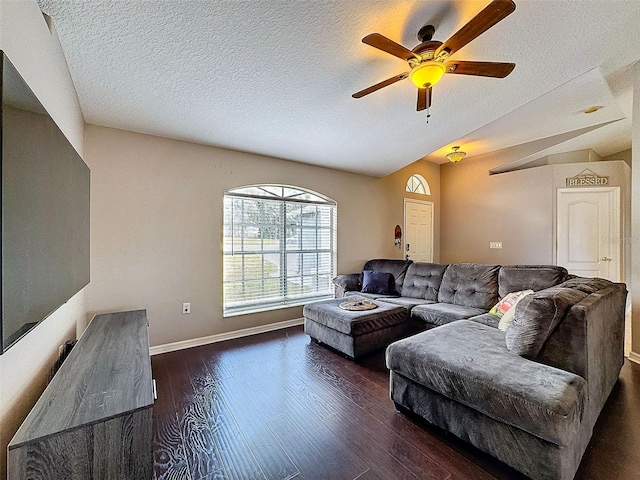 living room with dark wood-type flooring, lofted ceiling, a textured ceiling, and baseboards