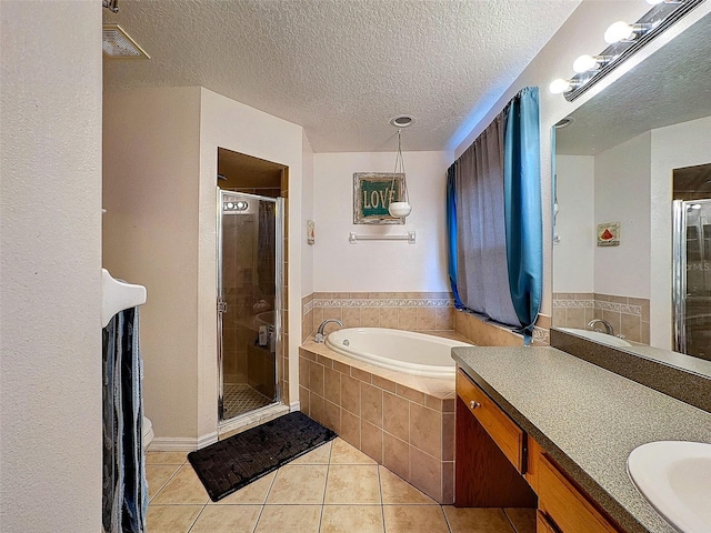 bathroom featuring a garden tub, a stall shower, vanity, a textured ceiling, and tile patterned floors