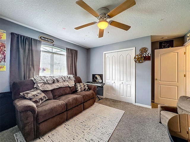 living room featuring carpet, ceiling fan, a textured ceiling, and baseboards