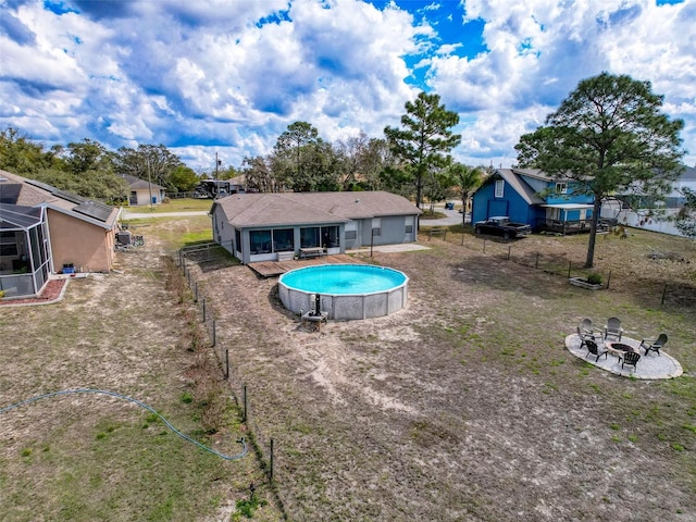 rear view of house featuring an outdoor fire pit, fence, and an outdoor pool