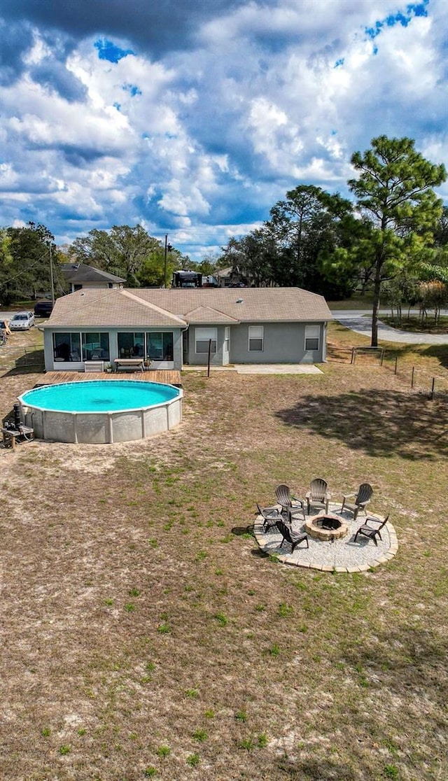 outdoor pool with a fire pit and a yard