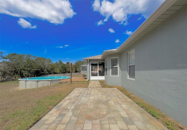 view of patio / terrace featuring a sunroom and an outdoor pool