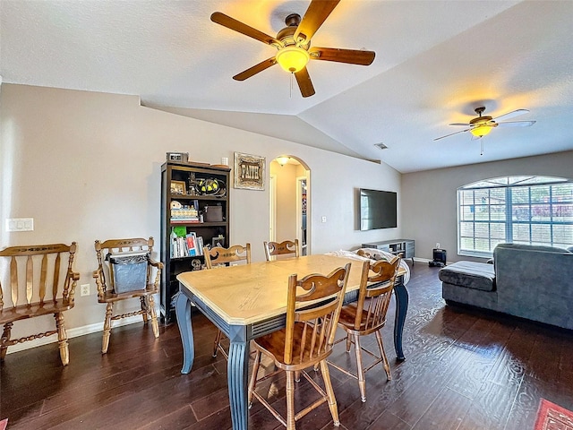 dining room with arched walkways, ceiling fan, lofted ceiling, visible vents, and dark wood finished floors