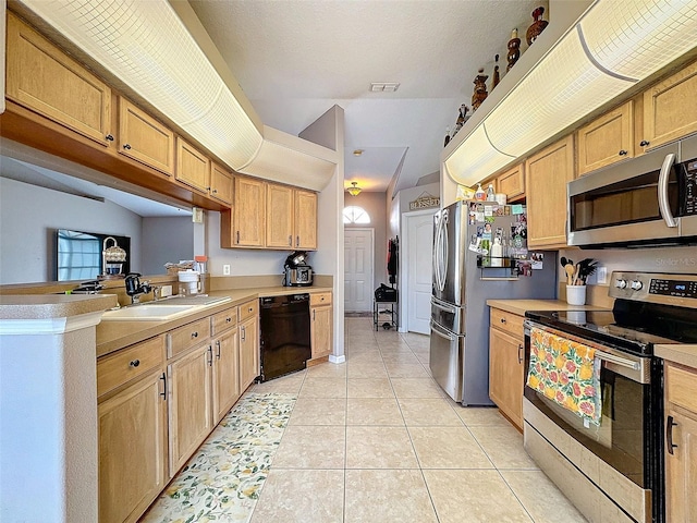 kitchen with light tile patterned floors, stainless steel appliances, a sink, and light countertops