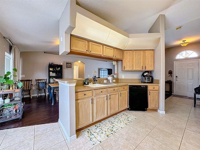 kitchen with a sink, light countertops, dishwasher, and light tile patterned flooring