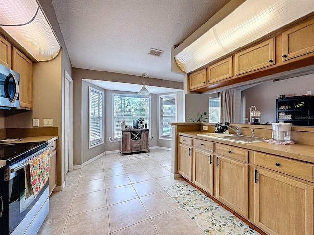 kitchen featuring light tile patterned floors, visible vents, appliances with stainless steel finishes, a textured ceiling, and a sink