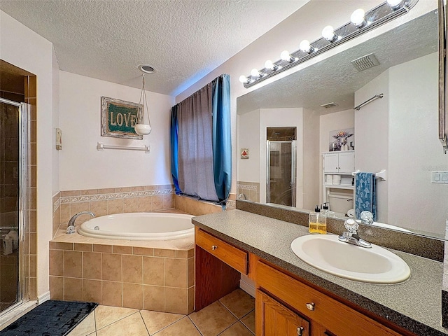 bathroom featuring a garden tub, a shower stall, a textured ceiling, and tile patterned floors