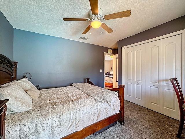 bedroom with a closet, visible vents, a ceiling fan, carpet flooring, and a textured ceiling