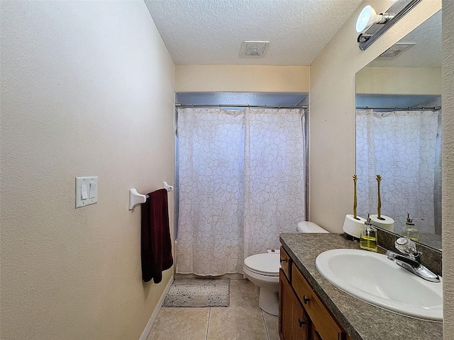 bathroom with a textured ceiling, toilet, vanity, visible vents, and tile patterned floors