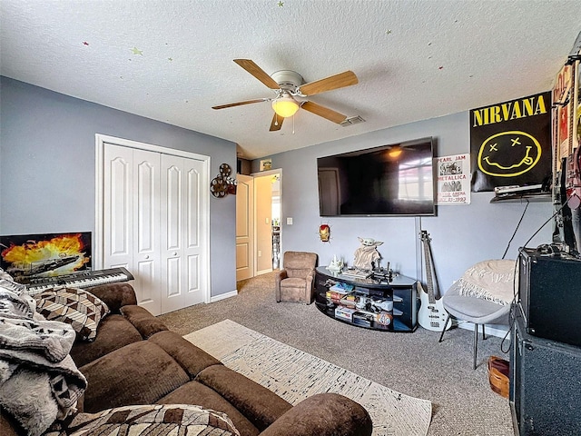 carpeted living room with a textured ceiling and a ceiling fan