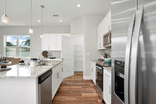 kitchen featuring visible vents, dark wood-style flooring, a sink, appliances with stainless steel finishes, and pendant lighting