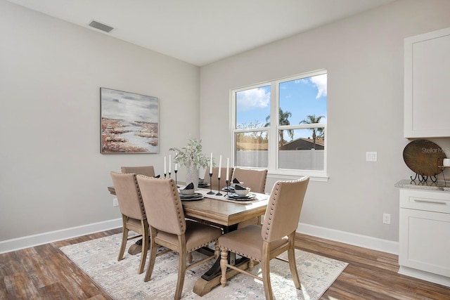 dining space featuring visible vents, baseboards, and wood finished floors