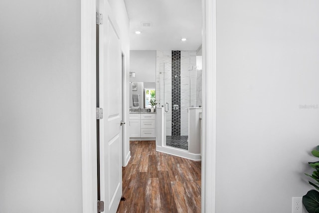 hall with dark wood-style floors, visible vents, and recessed lighting