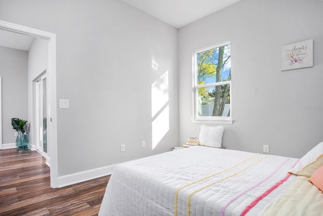 bedroom with dark wood-style floors and baseboards