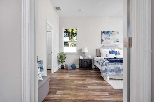 bedroom featuring visible vents and wood finished floors