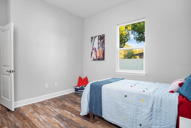 bedroom featuring baseboards and wood finished floors