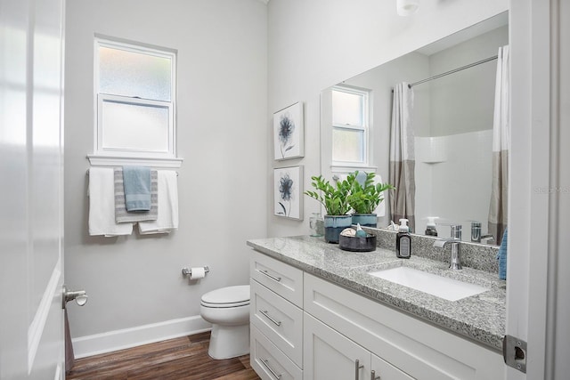full bathroom with vanity, a shower with curtain, wood finished floors, baseboards, and toilet