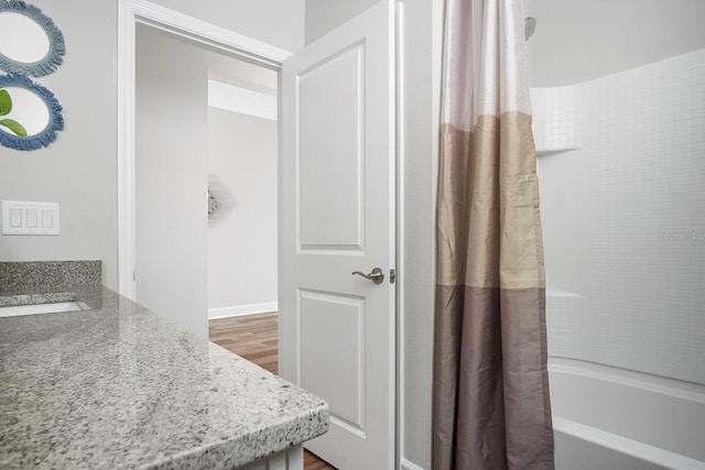 bathroom with vanity, shower / bath combination with curtain, and wood finished floors