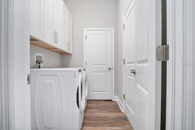 laundry area featuring dark wood-style floors, cabinet space, and washer and clothes dryer