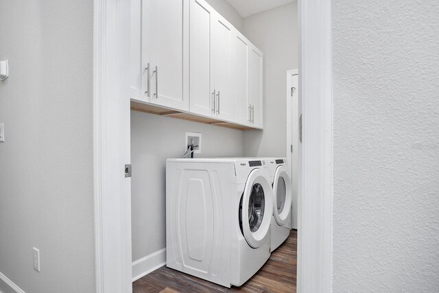clothes washing area with baseboards, cabinet space, separate washer and dryer, and dark wood-style flooring