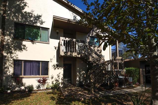 view of front of home featuring stucco siding and stairs