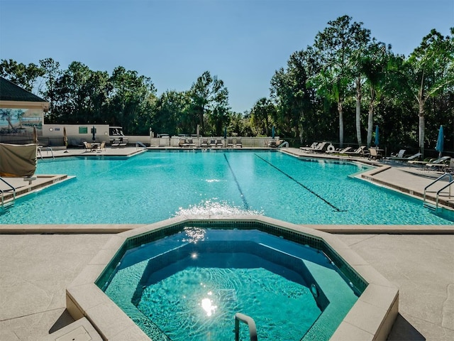 community pool featuring a patio area and a community hot tub