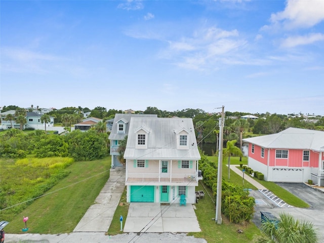 exterior space featuring an attached garage, a residential view, concrete driveway, and a yard