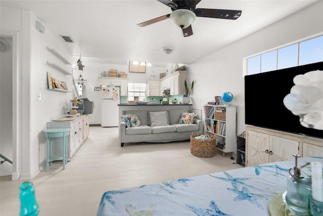 living area with ceiling fan, light wood-style flooring, and visible vents