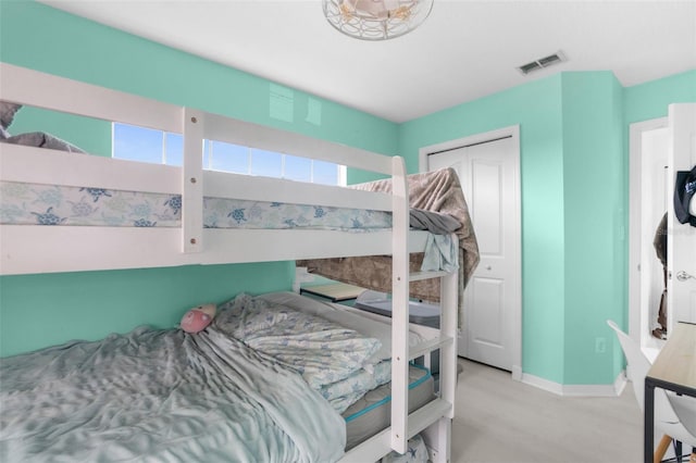 bedroom featuring a closet, wood finished floors, visible vents, and baseboards