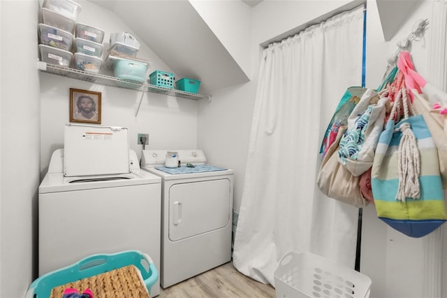 laundry area featuring light wood-style floors, laundry area, and washer and clothes dryer