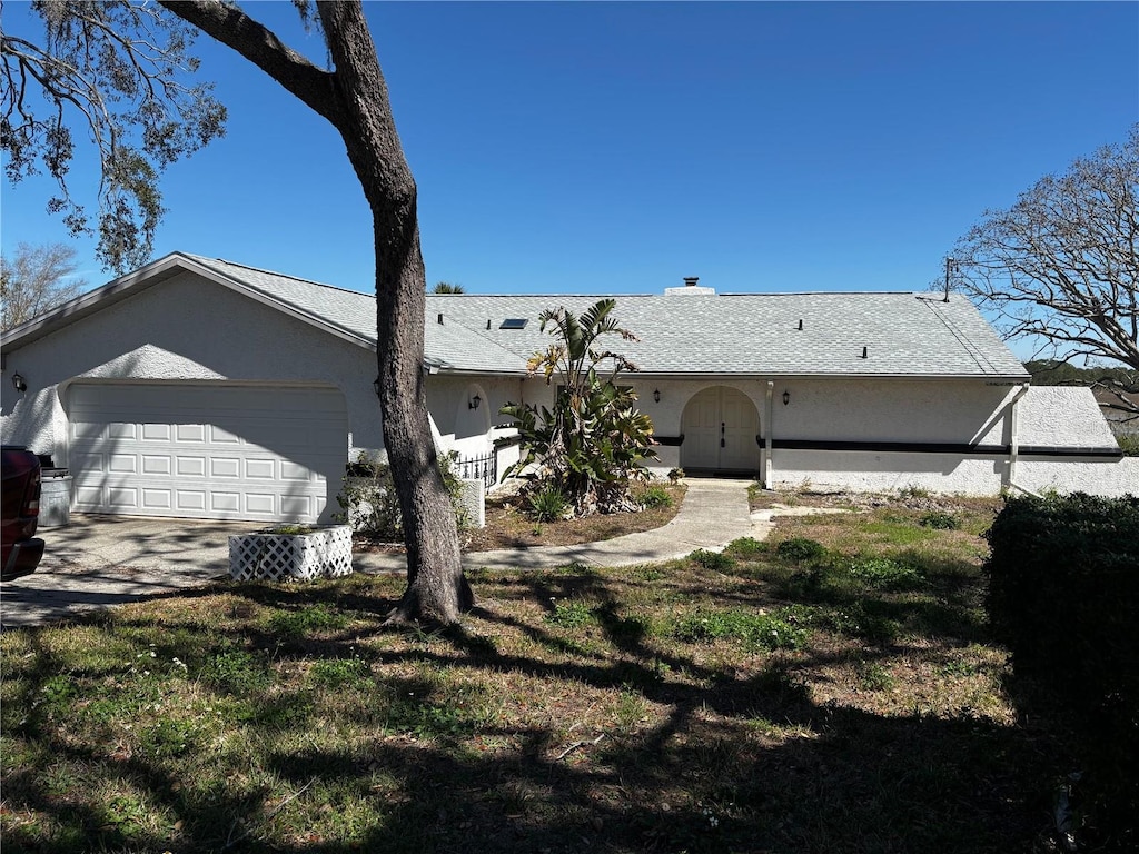 back of house with a garage and stucco siding