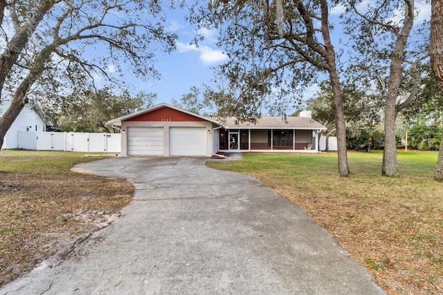 ranch-style home with driveway, a sunroom, an attached garage, a gate, and a front yard