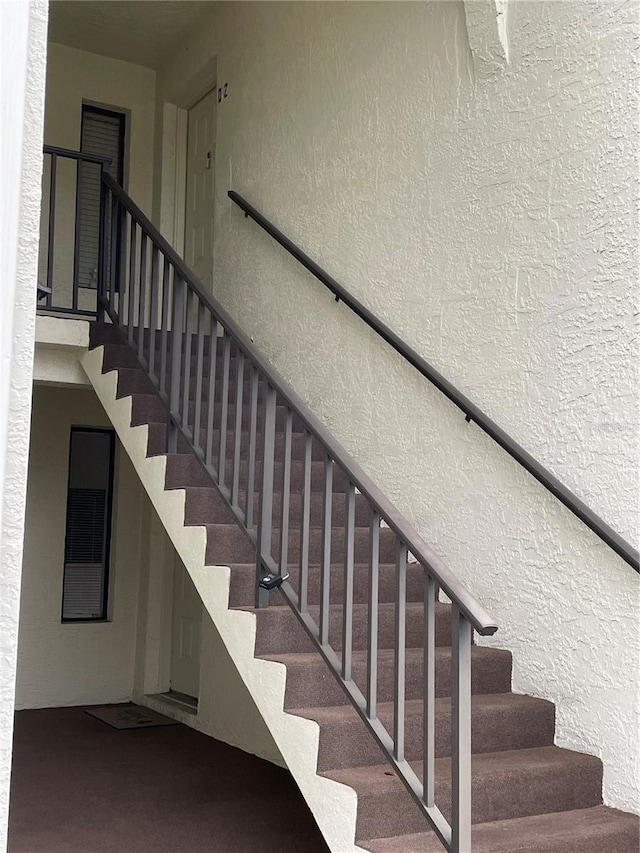 staircase featuring a textured wall