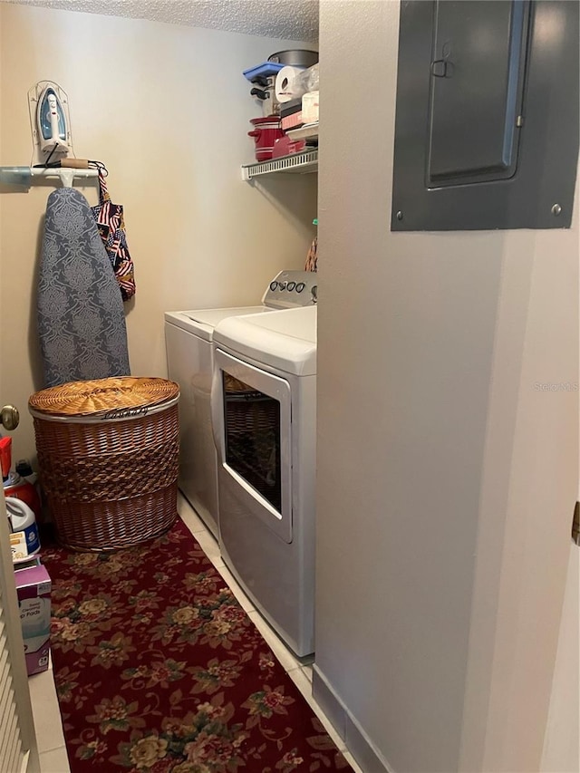 washroom featuring electric panel, laundry area, and washing machine and dryer