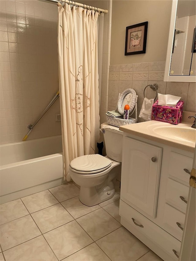 bathroom with tile patterned floors, toilet, shower / bath combo, tile walls, and vanity