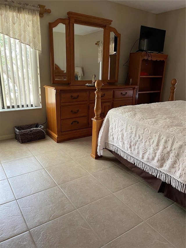 bedroom featuring baseboards and light tile patterned floors