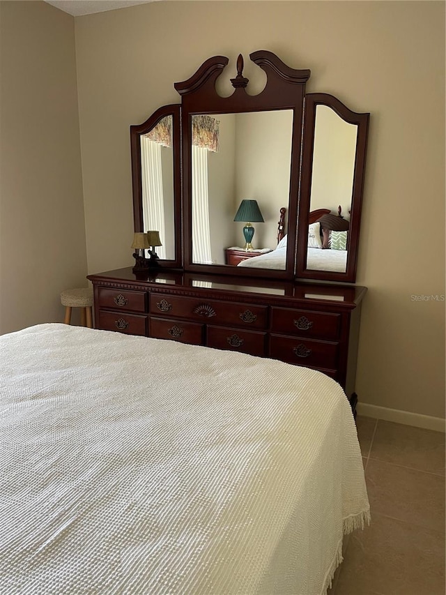 bedroom featuring baseboards and light tile patterned flooring